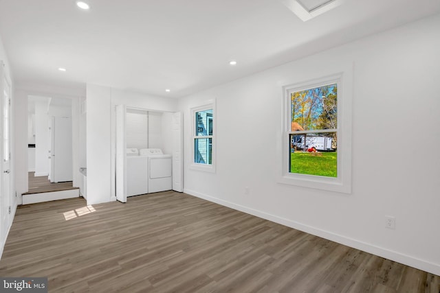 unfurnished bedroom featuring recessed lighting, wood finished floors, washing machine and clothes dryer, and baseboards