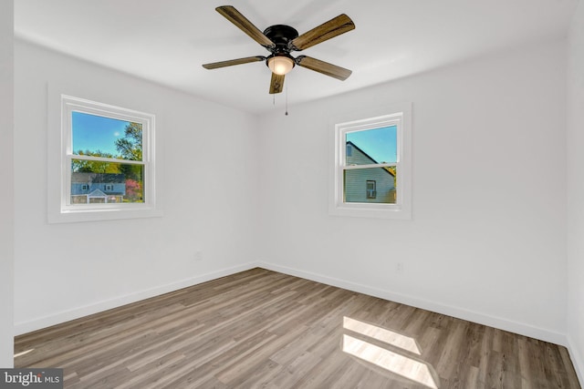 unfurnished room with baseboards, light wood-style floors, and plenty of natural light