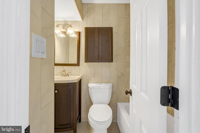 bathroom featuring tile walls, toilet, and vanity