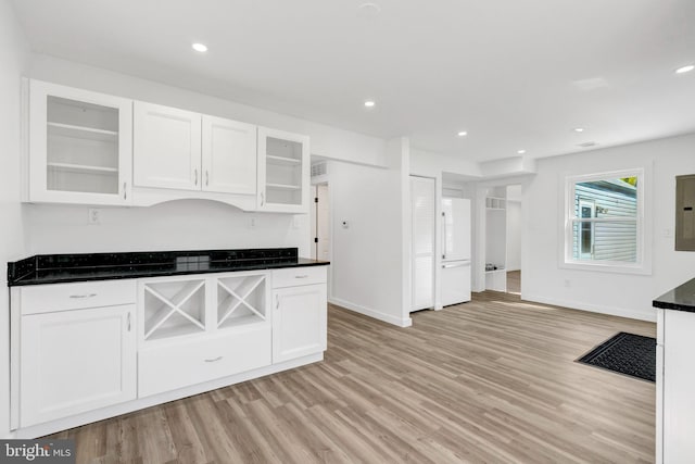 kitchen with light wood finished floors, baseboards, and white cabinetry