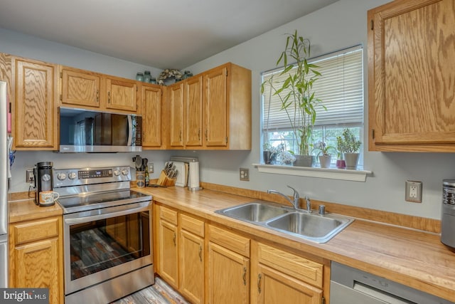 kitchen featuring a sink, appliances with stainless steel finishes, and wooden counters