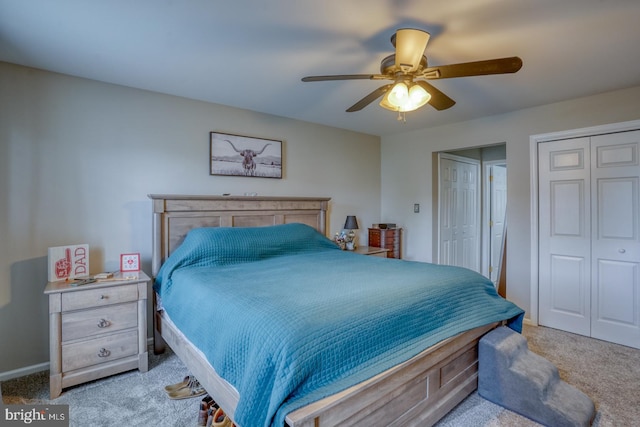 carpeted bedroom with a ceiling fan and two closets