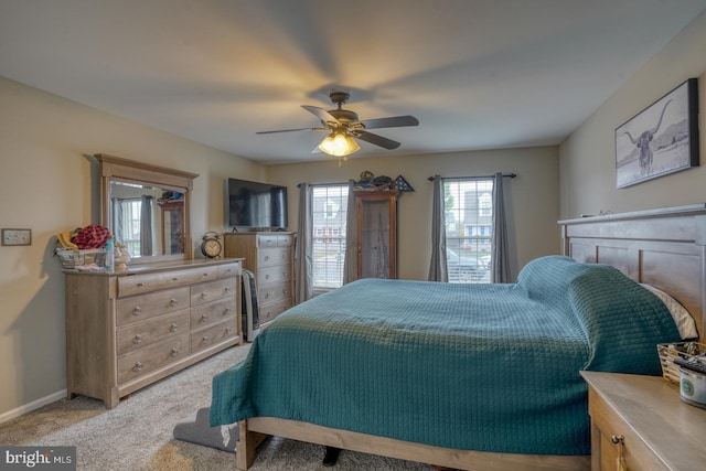bedroom with ceiling fan, light carpet, and baseboards