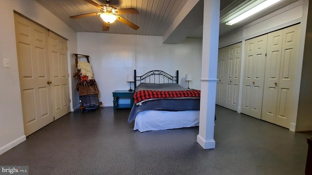 bedroom with two closets, baseboards, and ceiling fan