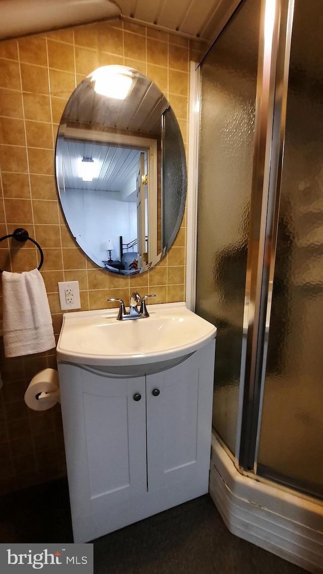 full bathroom with tile walls, decorative backsplash, vanity, and a shower stall