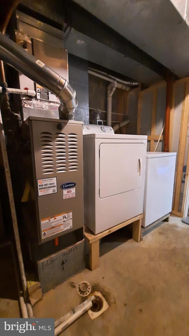 unfinished below grade area featuring fridge and washing machine and clothes dryer