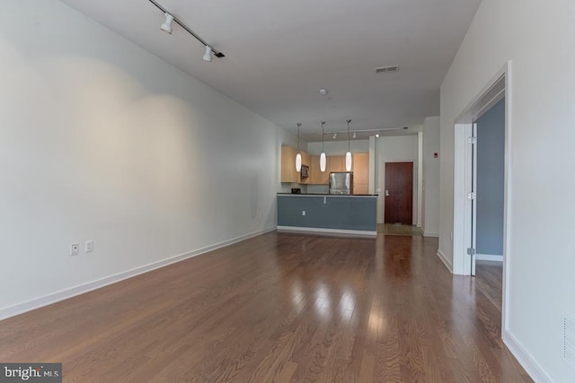 1209 N Charles St N Unit 209, Baltimore, MD 21201 - unfurnished living room with rail lighting, dark wood-type flooring, and baseboards