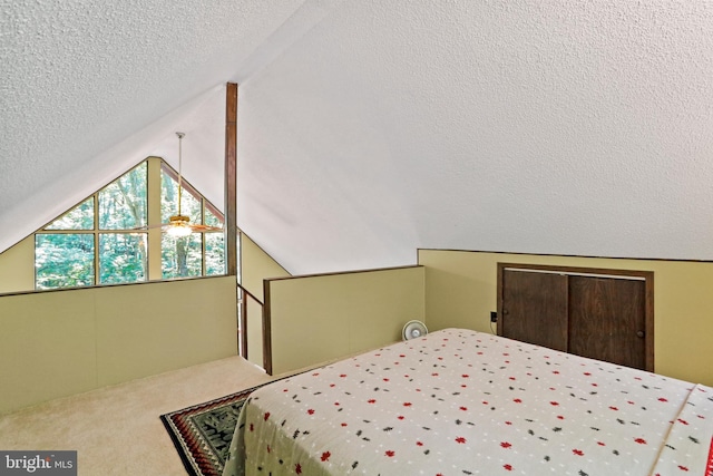 carpeted bedroom with lofted ceiling and a textured ceiling