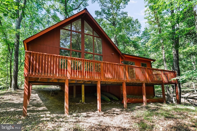 rear view of house featuring a carport and a wooden deck