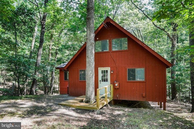 back of house with a view of trees