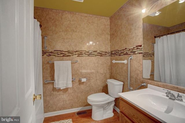 full bathroom with vanity, tile walls, toilet, and wood finished floors