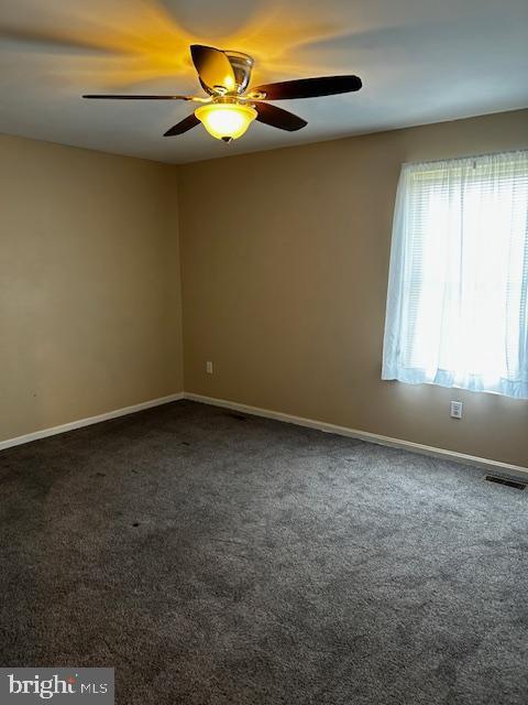 spare room with carpet flooring, ceiling fan, and baseboards