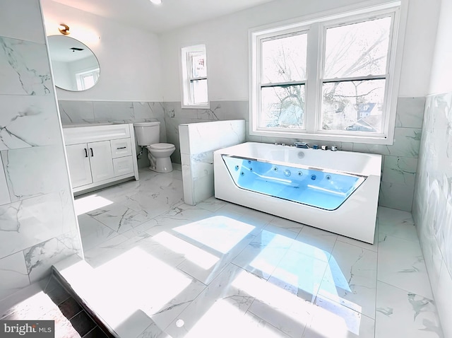 580 Bath St, Bristol, PA 19007 - bathroom featuring tile walls, wainscoting, marble finish floors, a tub with jets, and toilet