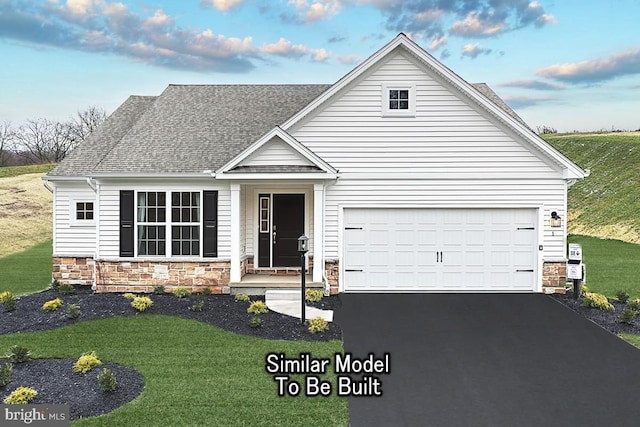 traditional-style house with a shingled roof, stone siding, a garage, a front lawn, and driveway