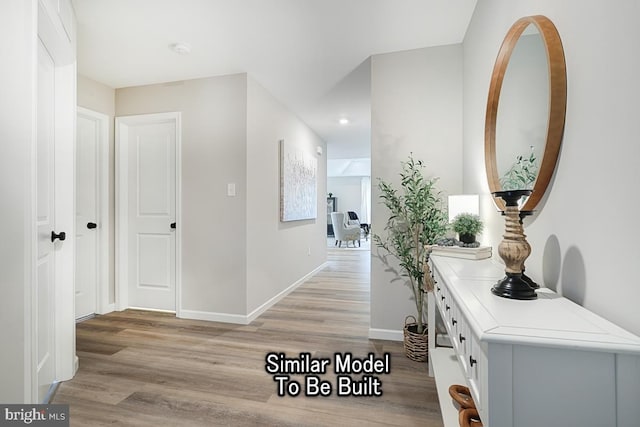 hallway featuring light wood-style floors and baseboards