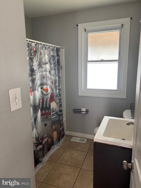 full bathroom featuring vanity, tile patterned flooring, visible vents, a shower with shower curtain, and baseboards
