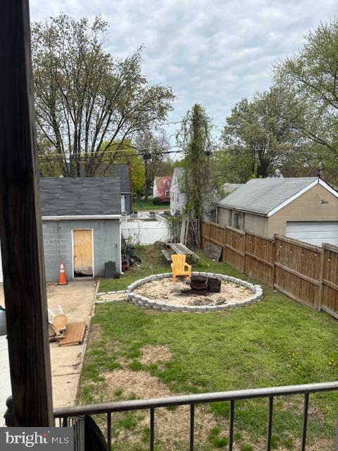 view of yard featuring an outdoor fire pit, an outbuilding, a fenced backyard, and a shed