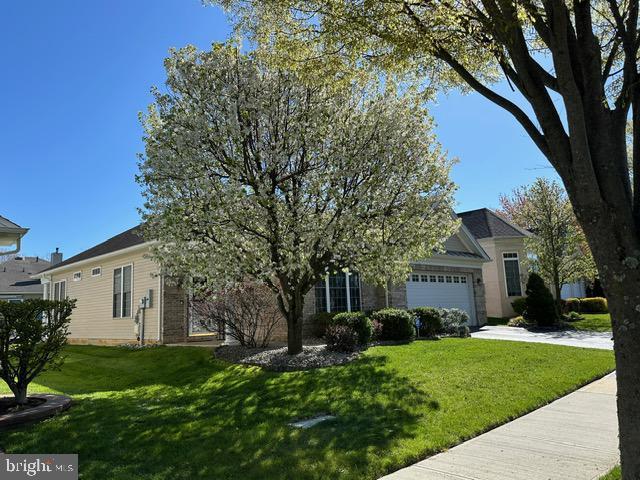 35 Galileo Dr, Cranbury, NJ 08512 - view of property hidden behind natural elements with concrete driveway, a front yard, and a garage