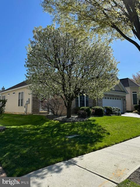 35 Galileo Dr, Cranbury, NJ 08512 - view of property hidden behind natural elements featuring an attached garage, driveway, and a front yard