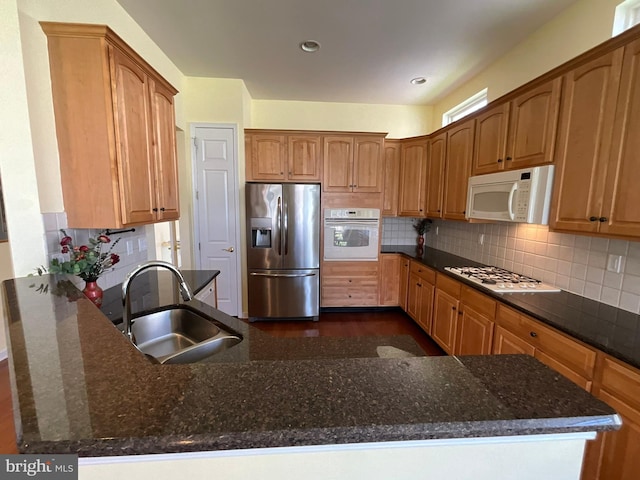 35 Galileo Dr, Cranbury, NJ 08512 - kitchen with dark stone countertops, backsplash, a sink, white appliances, and a peninsula