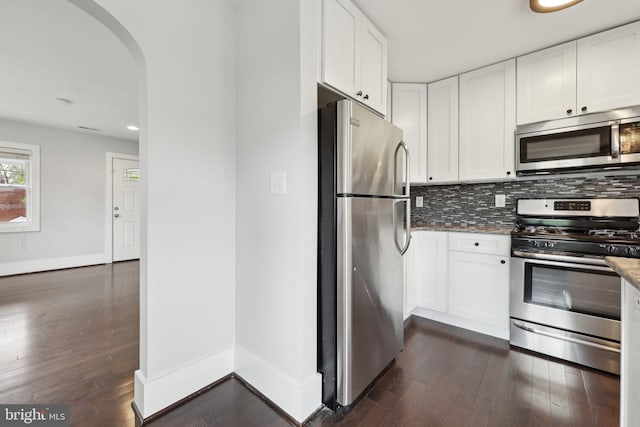 2026 Savannah Pl SE, Washington, DC 20020 - kitchen with stainless steel appliances, arched walkways, backsplash, and dark wood finished floors