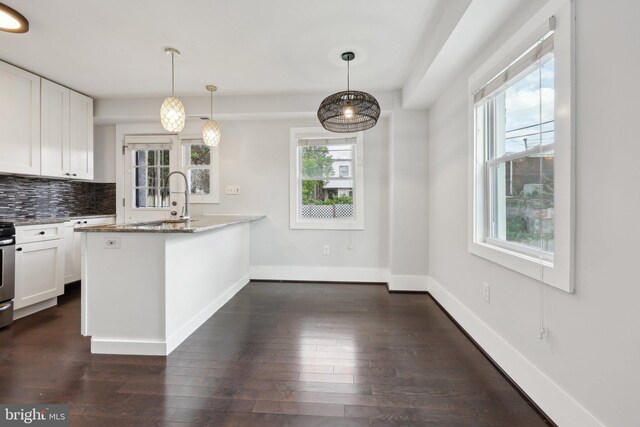 2026 Savannah Pl SE, Washington, DC 20020 - kitchen featuring a peninsula, dark wood-style floors, white cabinetry, backsplash, and light stone countertops