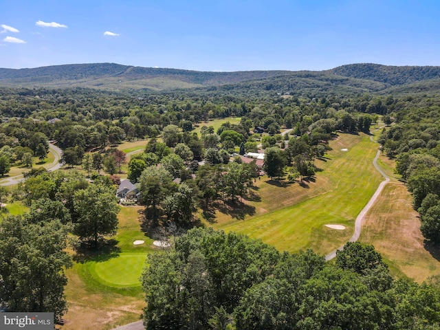 aerial view with a mountain view, view of golf course, and a forest view