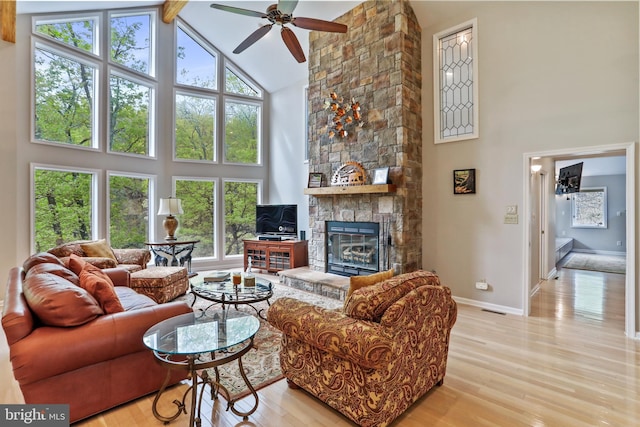 living area featuring high vaulted ceiling, ceiling fan, light wood-style flooring, and plenty of natural light