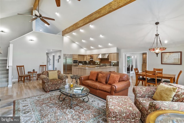 living room with beamed ceiling, a ceiling fan, high vaulted ceiling, and stairs