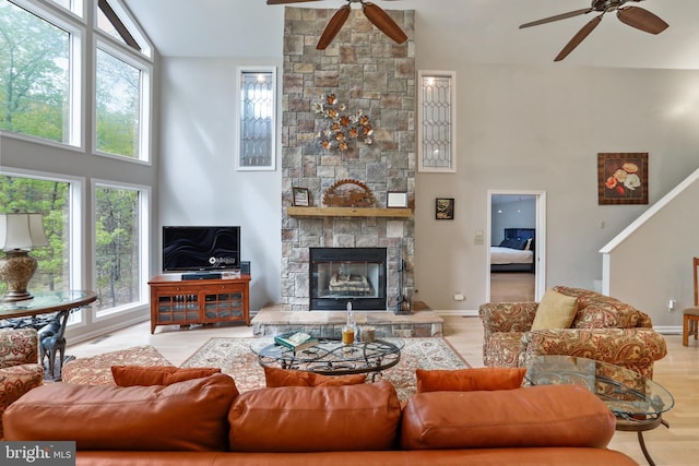 living room with a high ceiling, ceiling fan, and plenty of natural light