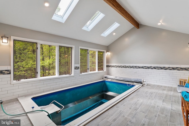 view of swimming pool featuring a skylight