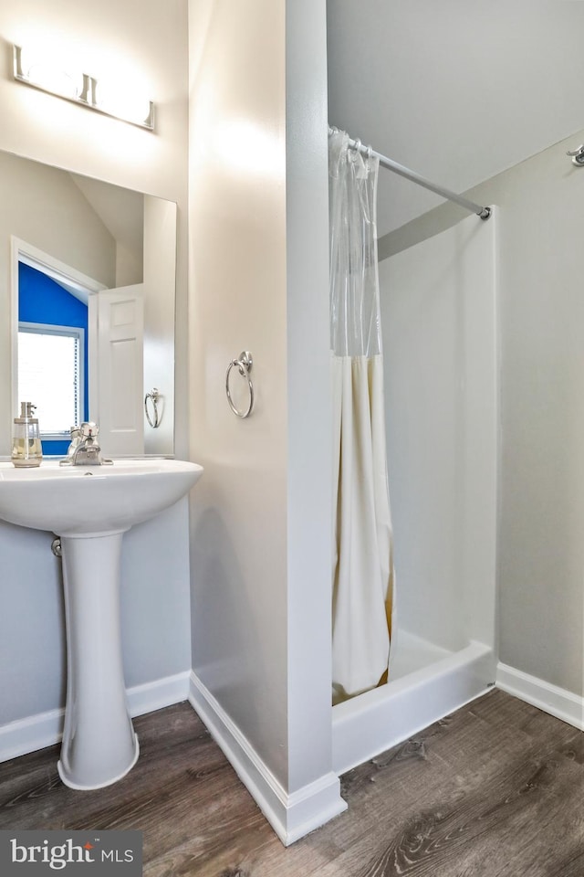 full bath with wood finished floors, a shower stall, and baseboards