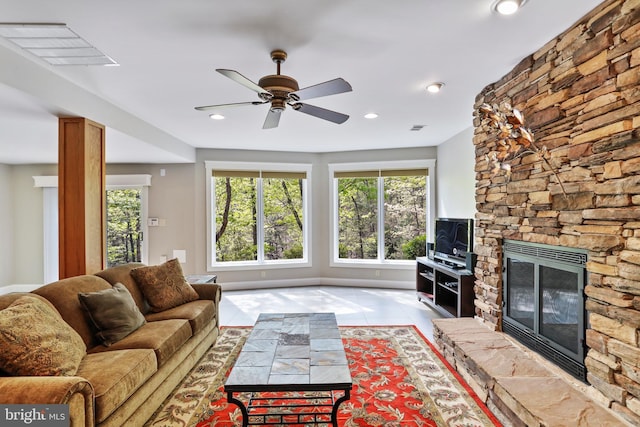 tiled living room with visible vents, ceiling fan, a wealth of natural light, and a fireplace