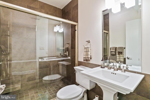 bathroom featuring tile walls, a stall shower, and toilet