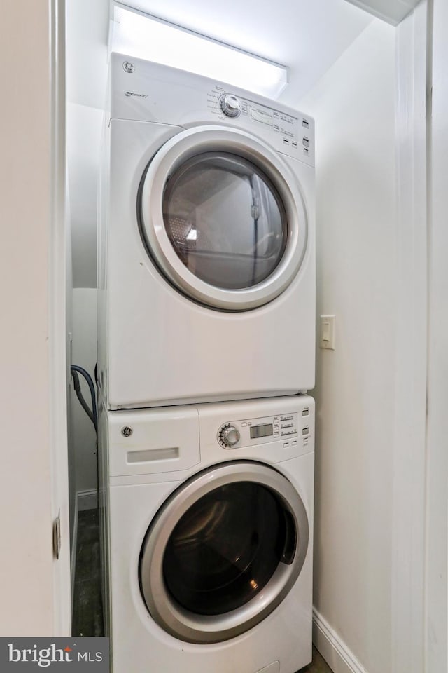 washroom with stacked washing maching and dryer