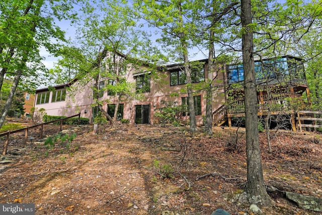 back of property featuring a wooden deck and stairs