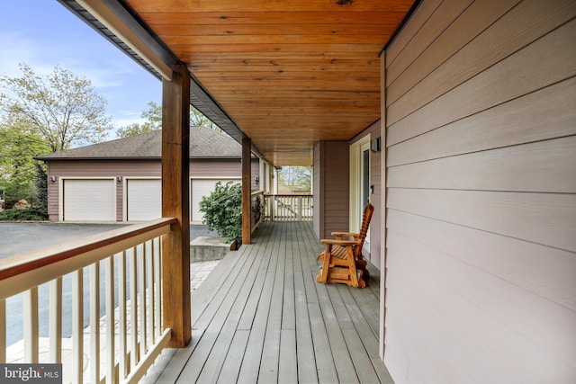 deck with a porch, an outdoor structure, and a garage