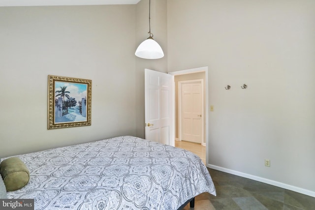 bedroom featuring baseboards and a high ceiling