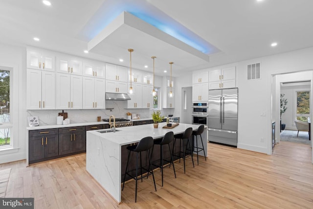 3418 Arnold Ln, Falls Church, VA 22042 - kitchen with light wood-type flooring, white cabinets, under cabinet range hood, visible vents, and appliances with stainless steel finishes