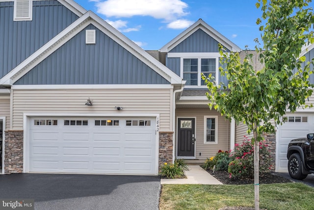 craftsman-style house featuring stone siding, driveway, board and batten siding, and a garage
