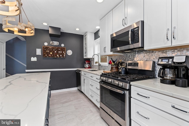1448 Sheridan St NW, Washington, DC 20011 - kitchen featuring stainless steel appliances, a sink, white cabinetry, backsplash, and light marble finish floors