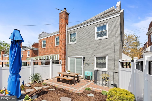 1448 Sheridan St NW, Washington, DC 20011 - back of house featuring a patio, a chimney, and a fenced backyard