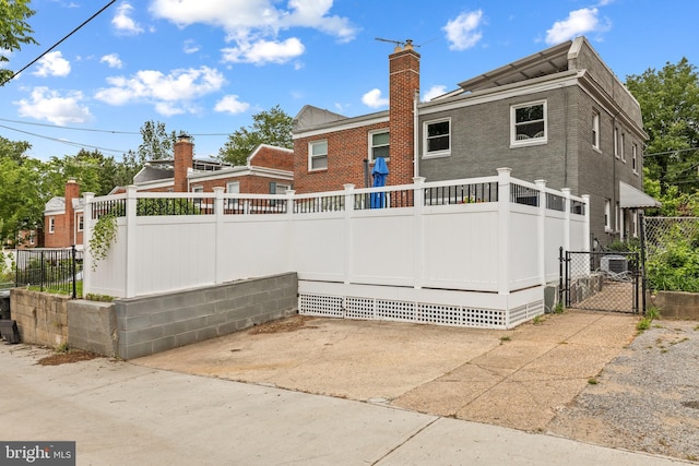 1448 Sheridan St NW, Washington, DC 20011 - rear view of property with a chimney, a gate, cooling unit, brick siding, and a patio