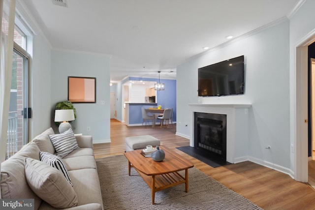 living room featuring baseboards, ornamental molding, recessed lighting, and wood finished floors