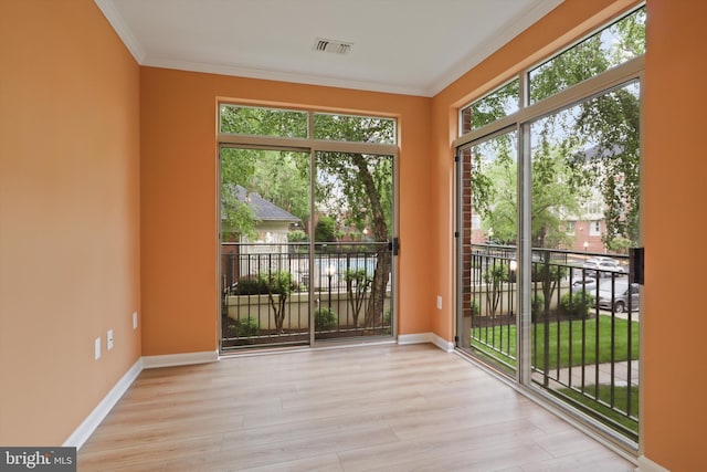entryway with baseboards, ornamental molding, visible vents, and wood finished floors