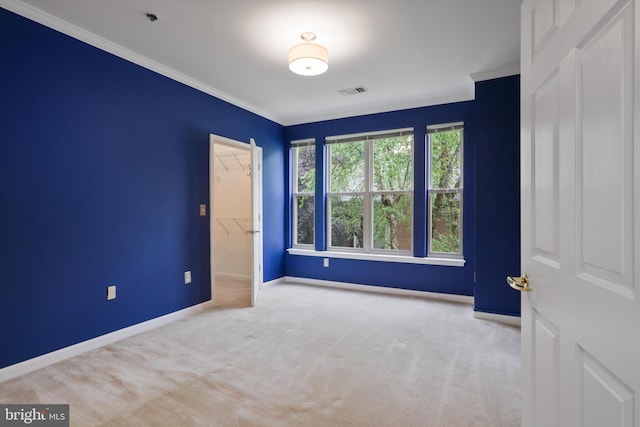 unfurnished bedroom with a closet, carpet floors, crown molding, visible vents, and baseboards