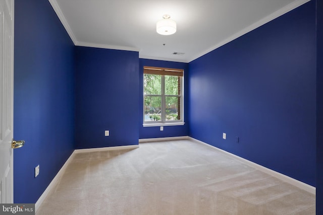 spare room with crown molding, visible vents, baseboards, and carpet floors