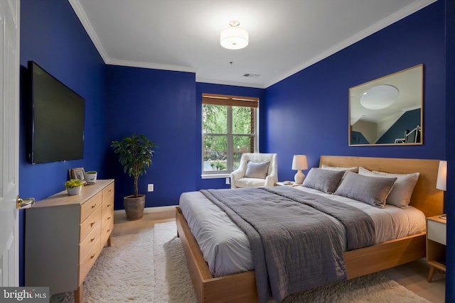 bedroom with baseboards, ornamental molding, and visible vents