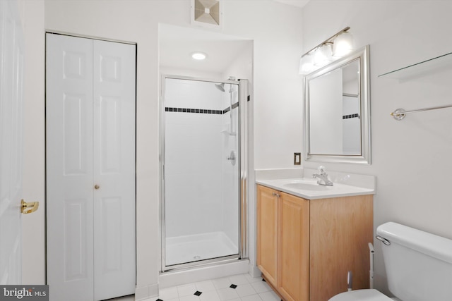 full bath with a stall shower, vanity, toilet, and a closet