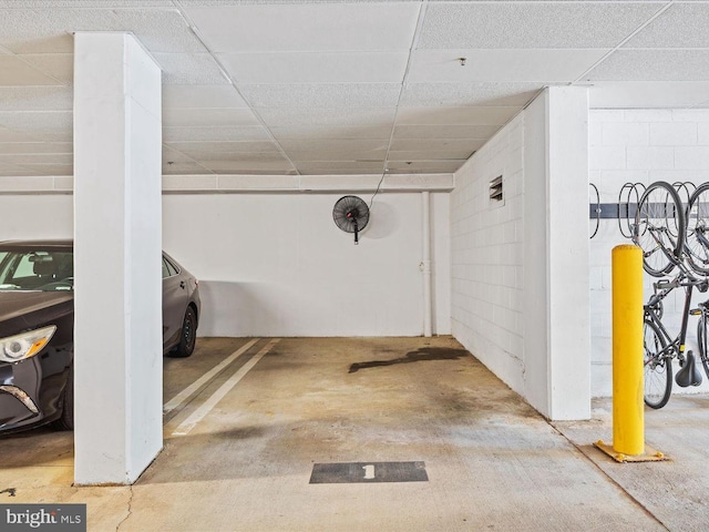 basement with a drop ceiling and concrete block wall